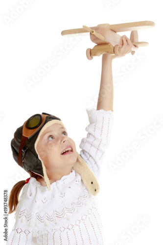 Little girl with a wooden plane in her hand.