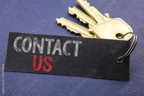 Handwritten text showing Contact Us. Business concept writing for Customer Support Written on note paper attached to the key, black background with space close up © Artur