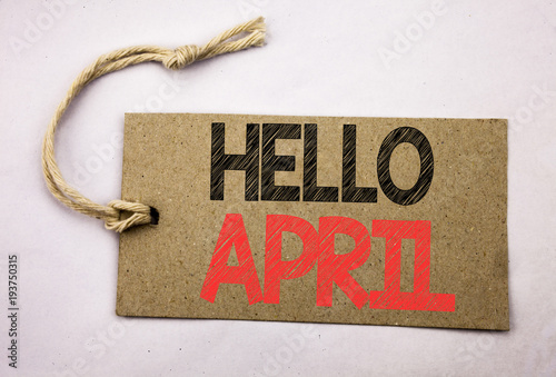 Hand writing text caption inspiration showing Hello April. Business concept for Spring Welcome written on price tag paper on the white vintage background. photo