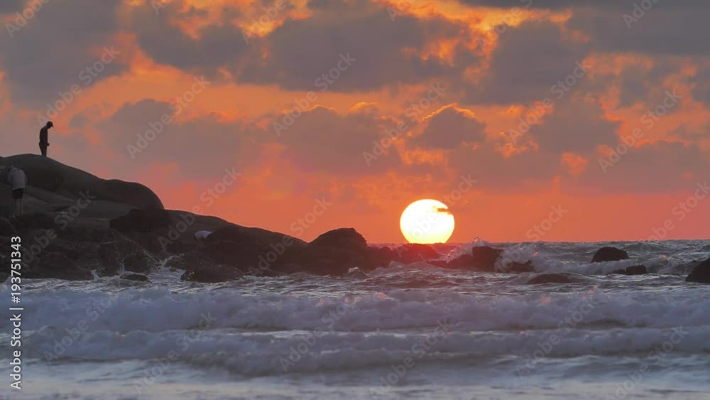 Beautiful Ocean sunset with last light of the Sun in sea waves crashing against rocks in slowmotion