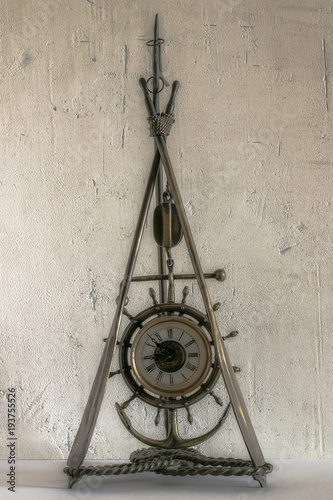 vintage mantel clock nautical theme on the background of a roughly plastered wall