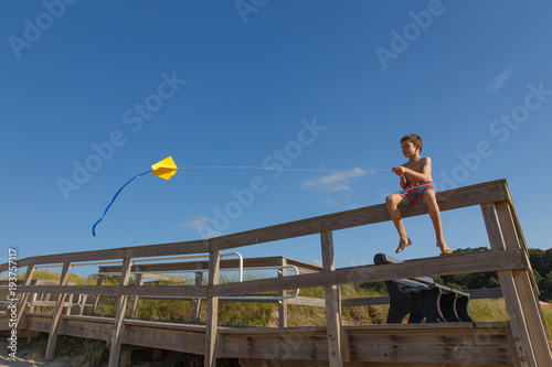 boy on the beach with a kite. child launches a kite on the seashore. copy space for your text