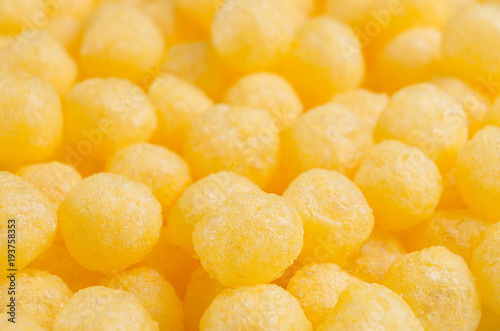 Cheesy corn sticks balls closeup as background.