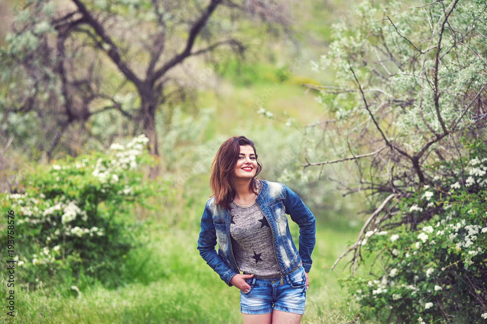 Young woman on a walk in the field .Girl with field flowers in her hands Young woman on a walk in the field .Girl with field flowers in her hands