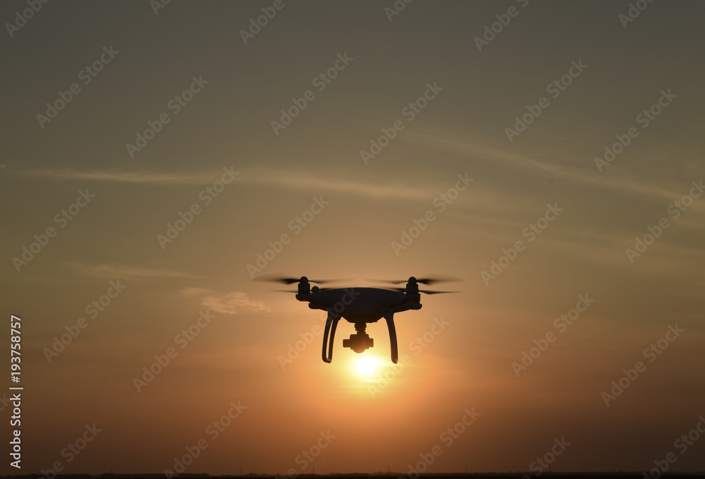Quadrocopters silhouette against the background of the sunset Quadrocopters silhouette against the background of the sunset
