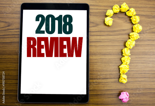 Word, writing 2018 Review. Business concept for Feedback On Progress Written on tablet, wooden background with question mark on the end. photo