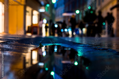 Reflection of streets and people in puddles of rain