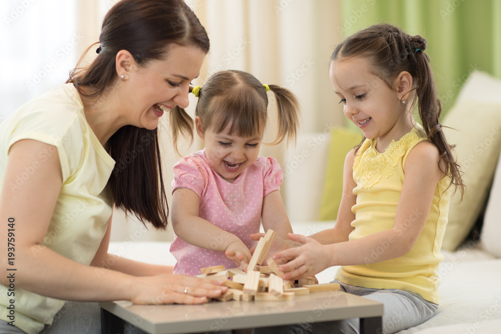 Family mom and daughters having a fun playing board game at table Family mom and daughters having a fun playing board game at table