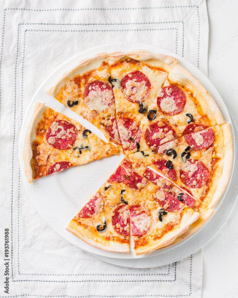 Italian Pepperoni pizza with salami on white wooden background. Italian traditional food. Popular street food. Flat lay, top view. Italian Pepperoni pizza with salami on white wooden background. Italian traditional food. Popular street food. Flat lay, top view.