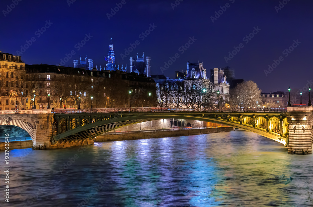 Twilight view onto the Seine at Pont Notre Dame Bridge in Paris France