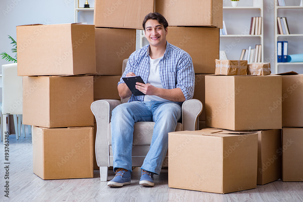 Young man moving in to new house with boxes Young man moving in to new house with boxes