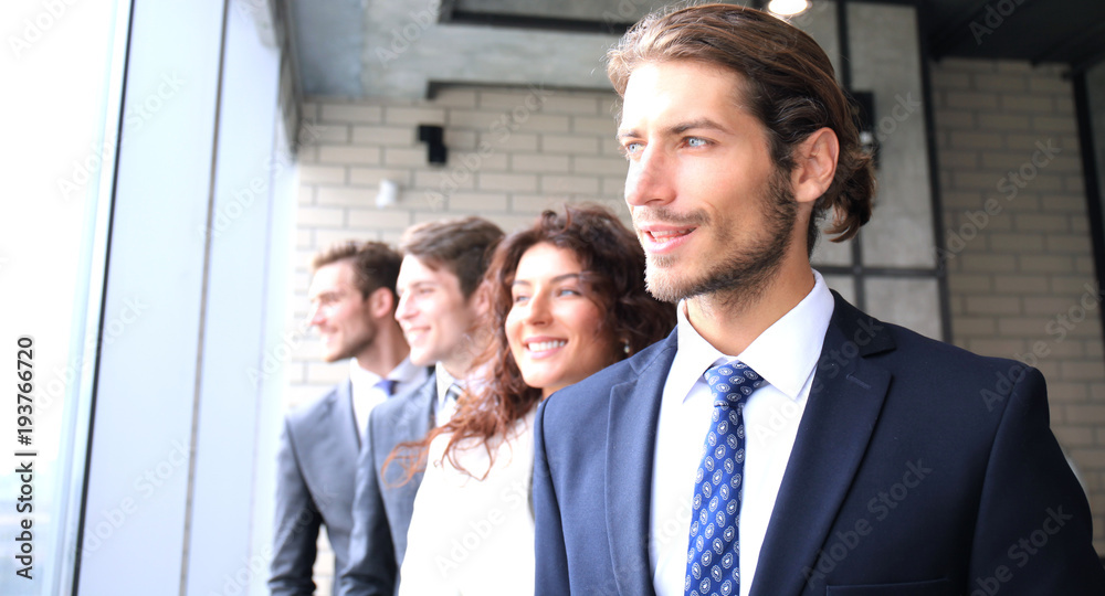 Happy smiling business team standing in a row at office. Happy smiling business team standing in a row at office.
