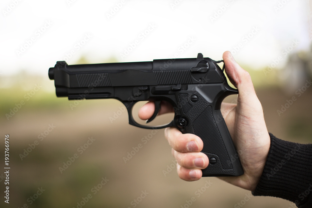 Killer with gun close up over grunge background with copyspace. Killer with gun close up over grunge background with copyspace.