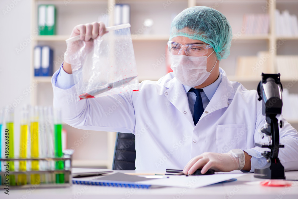 Forensics investigator working in lab on crime evidence Forensics investigator working in lab on crime evidence