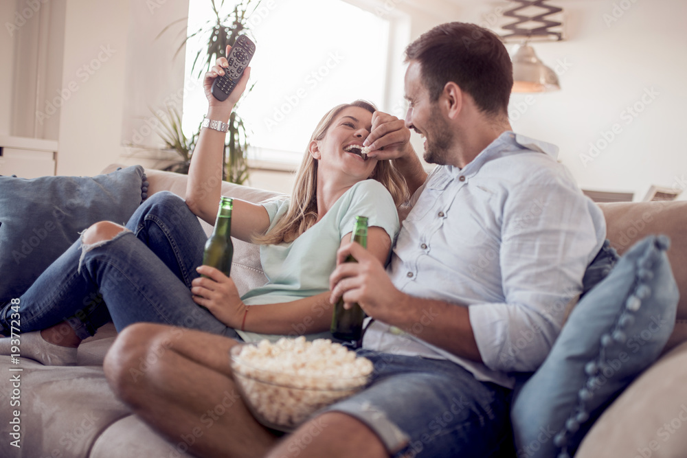 Couple watching TV and eating popcorn. Couple watching TV and eating popcorn.