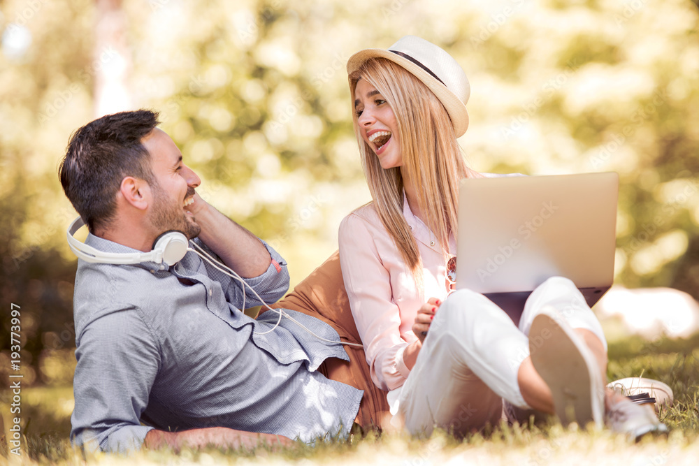 Young couple using laptop in the park