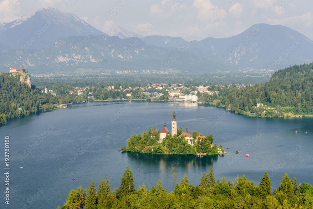 Colorful summer scene on the Bled lake with the famous Pilgrimage Church of the Assumption of Maria and Bled Castle and Julian Alps at background - obrazy, fototapety, plakaty 
