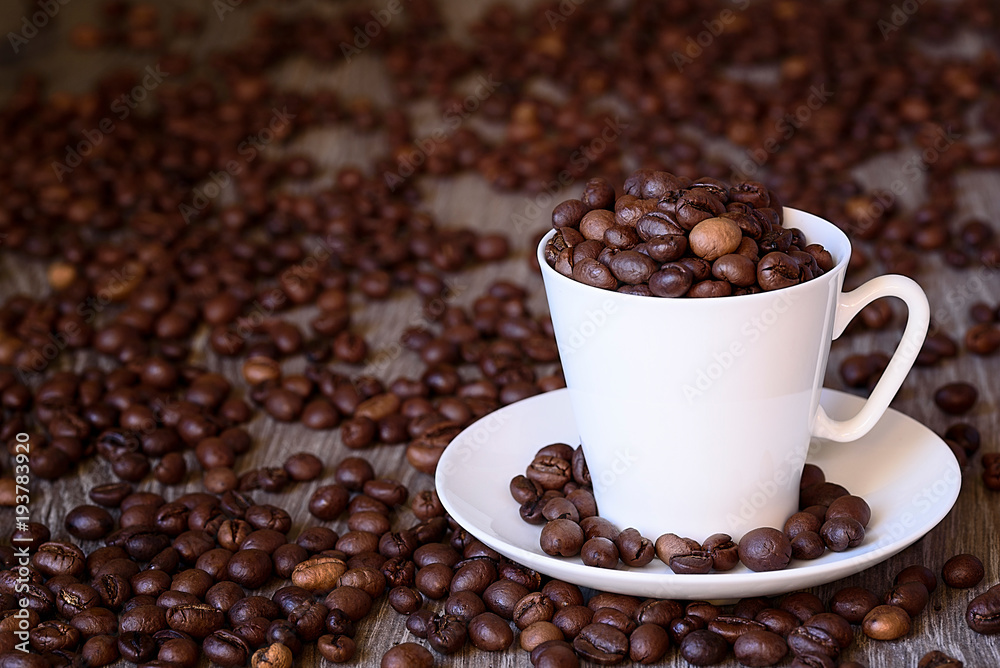 Coffee concept: fried coffee beans in porcelain white coffee cup Coffee concept: fried coffee beans in porcelain white coffee cup