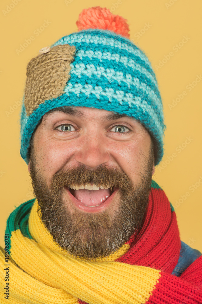 Cheerful man with beard and mustache wearing fashionable scarf and hat. Male winter fashion. Handsome man in hat and scarf. Attractive bearded man in warm knitted hat and scarf. Closeup portrait. Cheerful man with beard and mustache wearing fashionable scarf and hat. Male winter fashion. Handsome man in hat and scarf. Attractive bearded man in warm knitted hat and scarf. Closeup portrait.