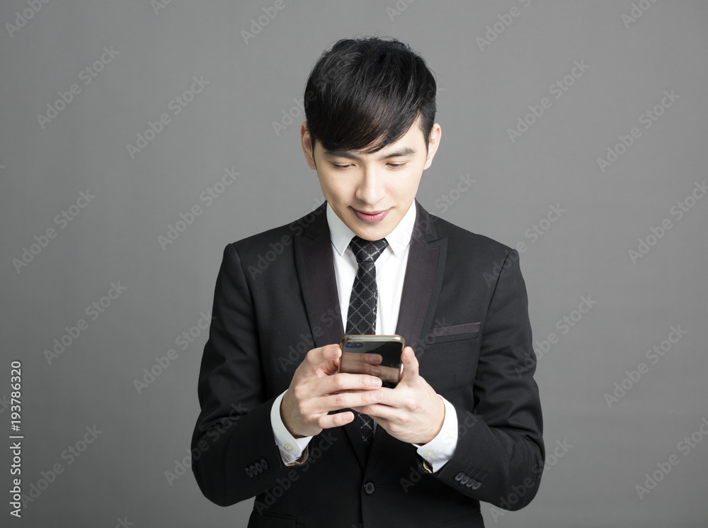 young business man holding the smart phone . young business man holding the smart phone .