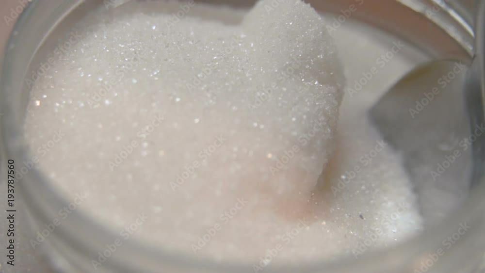 Close up of jar of sugar and putting spoon on it