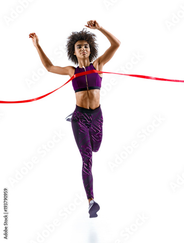 Woman running, crossing finish line. Photo of young african woman isolated on white background. Sport and healthy lifestyle. Dynamic movement. Competition event