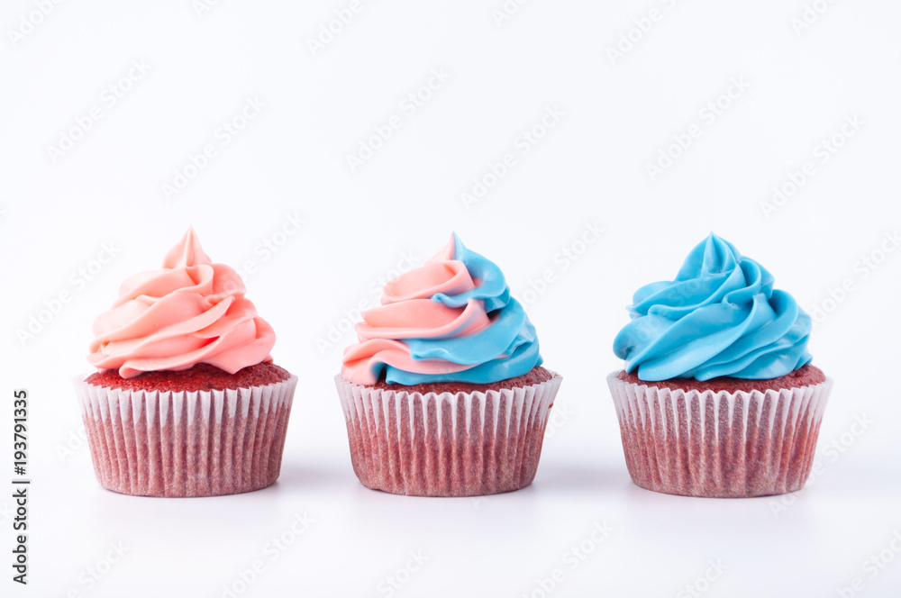 Cupcakes red velvet with blue and pink whipped cream on white background. Picture for a menu or a confectionery catalog. Cupcakes red velvet with blue and pink whipped cream on white background. Picture for a menu or a confectionery catalog.
