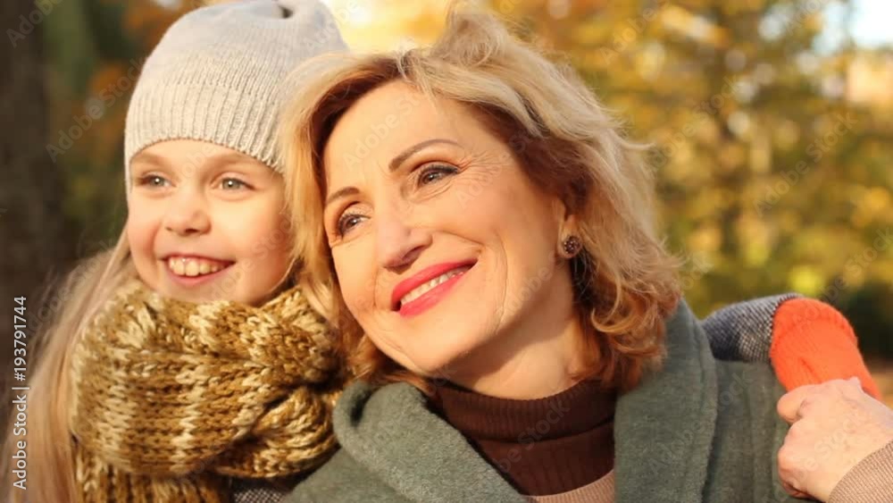 Happy age. Happy, smiling, little, beautiful girl hugging her grandmother Happy age. Happy, smiling, little, beautiful girl hugging her grandmother