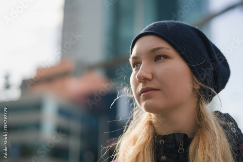 urban portrait of teen girl walking in the city in autumn or spring