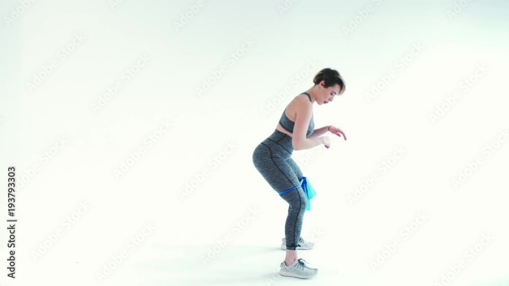 Fitness woman doing exercises with elastic bands on white background Fitness woman doing exercises with elastic bands on white background