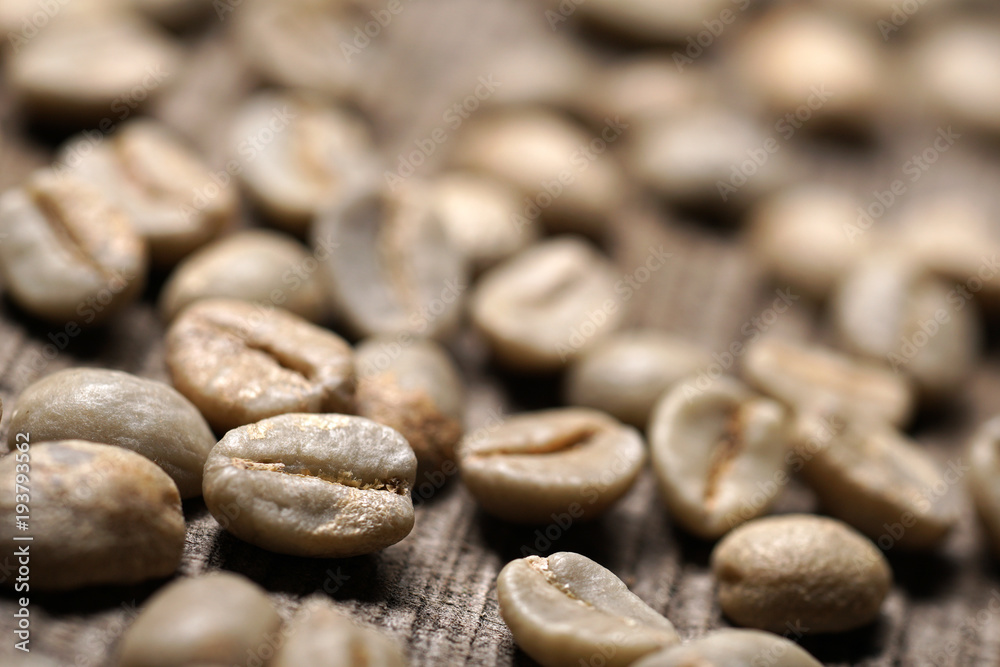 Unroasted or green coffee beans on wooden background - Macro Unroasted or green coffee beans on wooden background - Macro