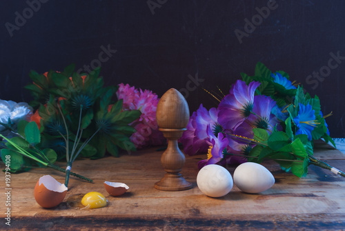Easter eggs in composition with flowers in rustic style, photo