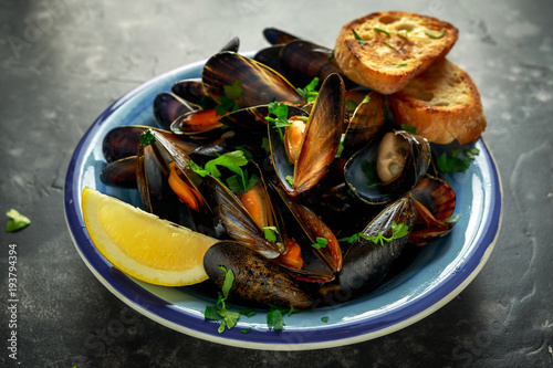 Mussels in garlic butter sauce served with parsley, toast and lemon