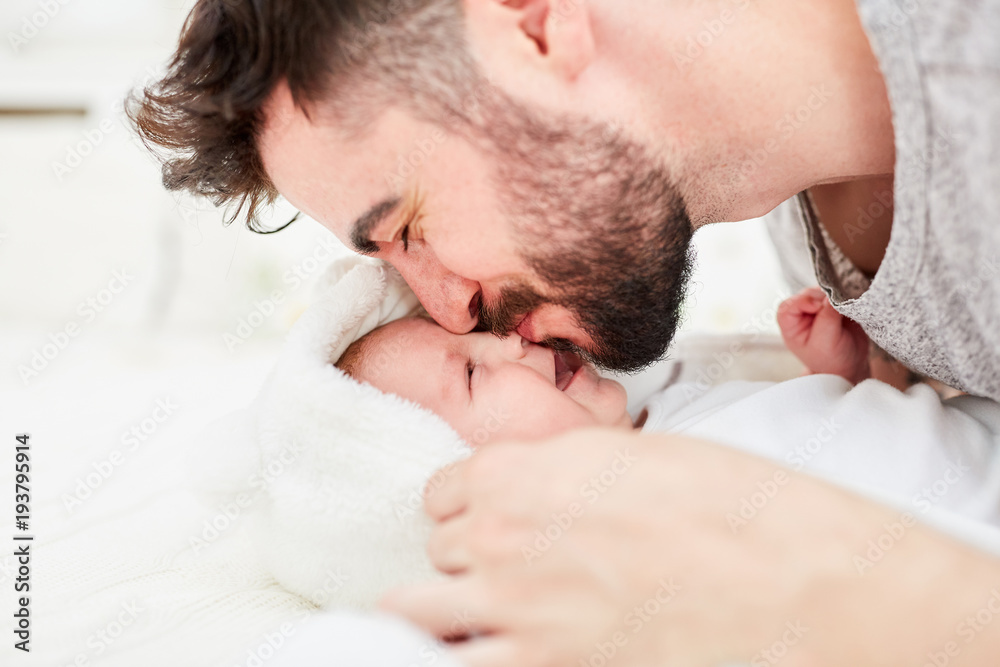 Vater gibt Baby einen Kuss auf die Stirn Vater gibt Baby einen Kuss auf die Stirn