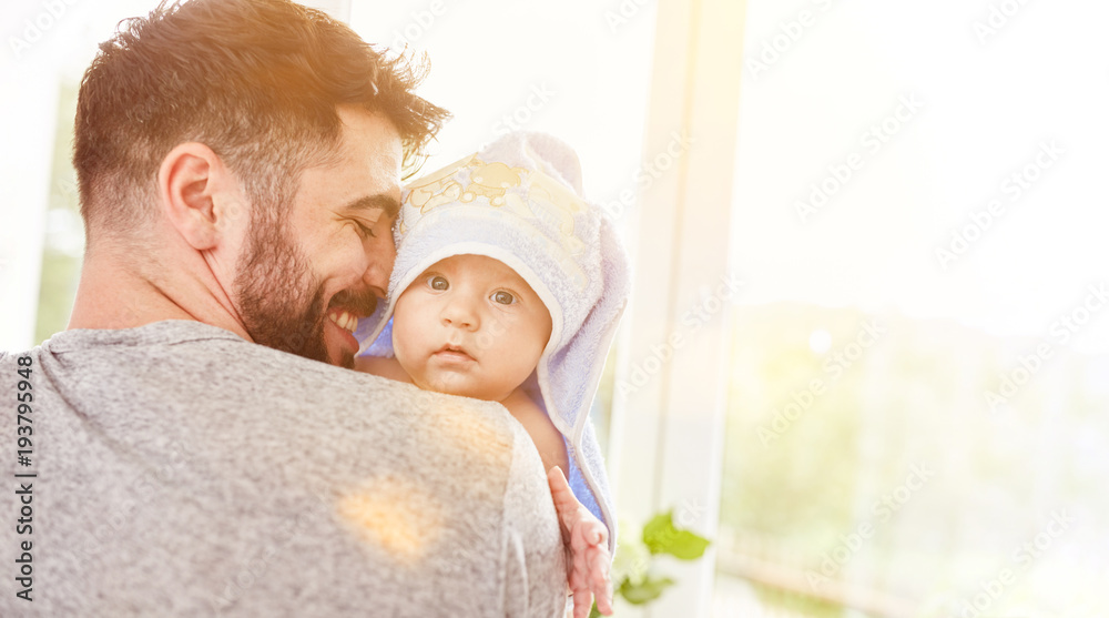 Stolzer Vater trägt sein Baby nach dem Baden - obrazy, fototapety, plakaty 