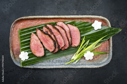 Japanese barbecue wagyu aged fillet steak slices with daikon and leek as top view on a plate