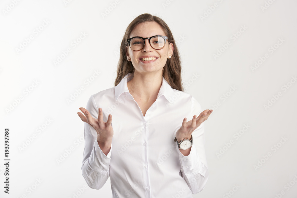 Portrait of happy young businesswoman wearing white shirt while standing with her arms rasied and wondering. Isolated on white background. Portrait of happy young businesswoman wearing white shirt while standing with her arms rasied and wondering. Isolated on white background.