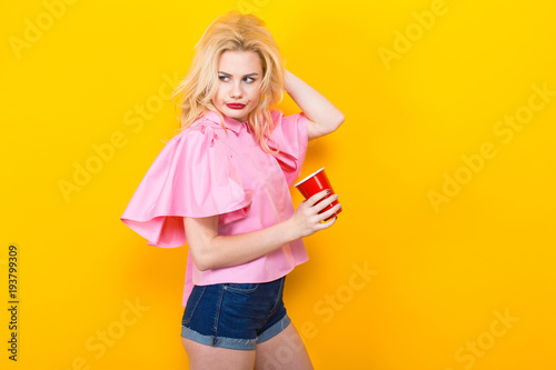 Blonde woman in pink blouse with red cup