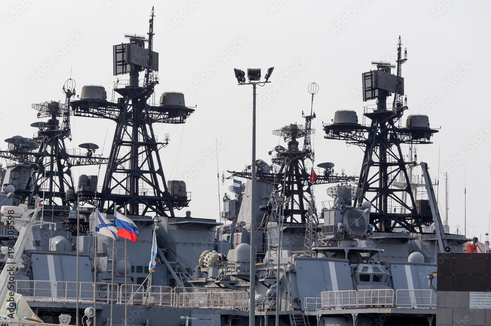 Superstructure of modern russian military cruiser battleship. Russian Navy Ensign and flags on the ship board. Russia, Vladivostok. Superstructure of modern russian military cruiser battleship. Russian Navy Ensign and flags on the ship board. Russia, Vladivostok.