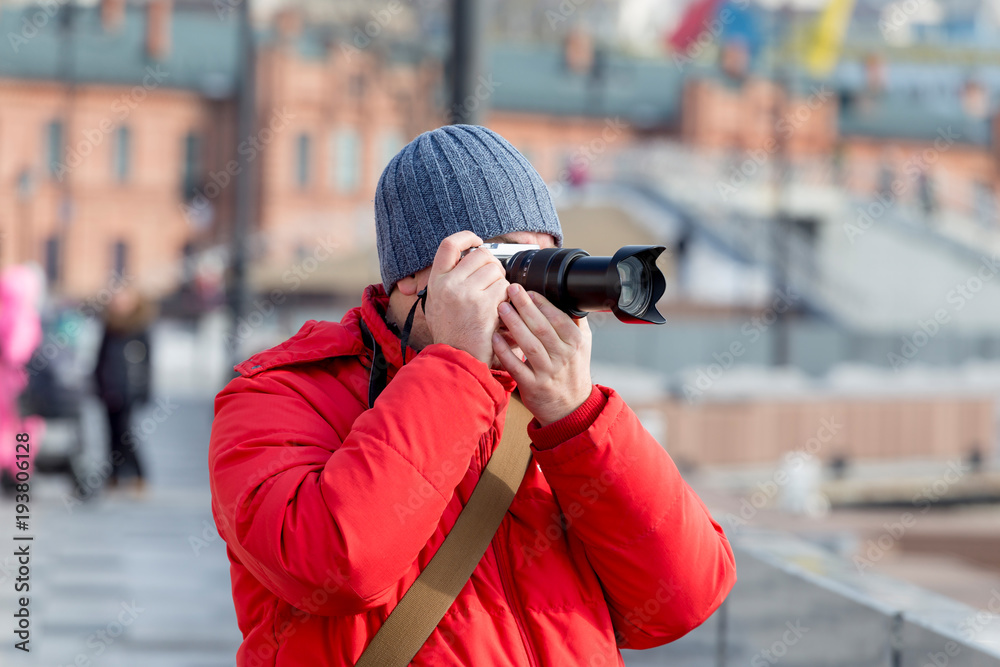 Portrait of tourist taking a photo on a street with modern digital camera. Tourism and travelling. Photographers and their equipment. Street photo. Portrait of tourist taking a photo on a street with modern digital camera. Tourism and travelling. Photographers and their equipment. Street photo.
