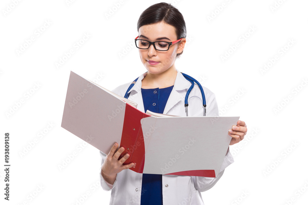 Young woman doctor with stethoscope holding binder in her hands in white uniform on white background Young woman doctor with stethoscope holding binder in her hands in white uniform on white background