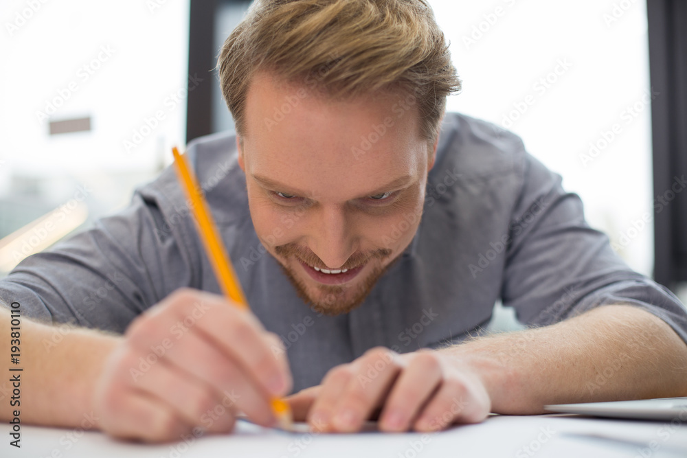 Joyful nice man concentrating on his work Joyful nice man concentrating on his work