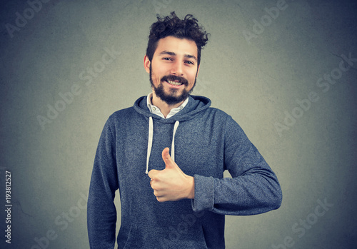 Content successful hipster gesturing on gray