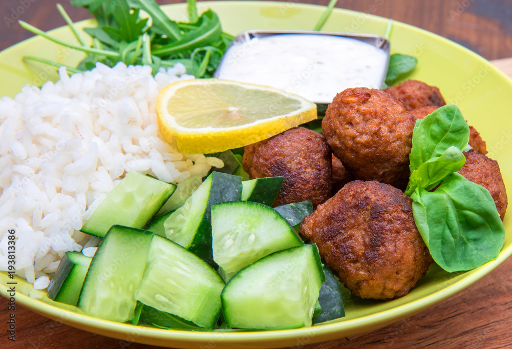 vegan dish with soymeatballs, cucumber,rice and yogurt sauce vegan dish with soymeatballs, cucumber,rice and yogurt sauce
