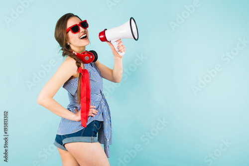 Young sexy woman with headphones and loudspeaker