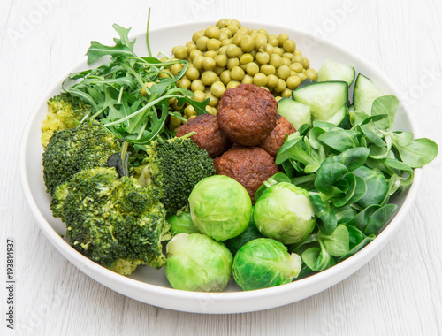 vegan dish with soy meatballs and green vegetables