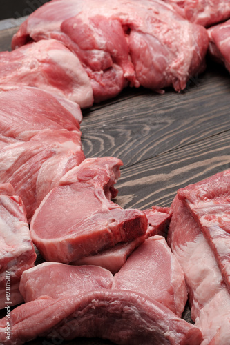 Assorted raw meat on a wooden dark background. Mock-up