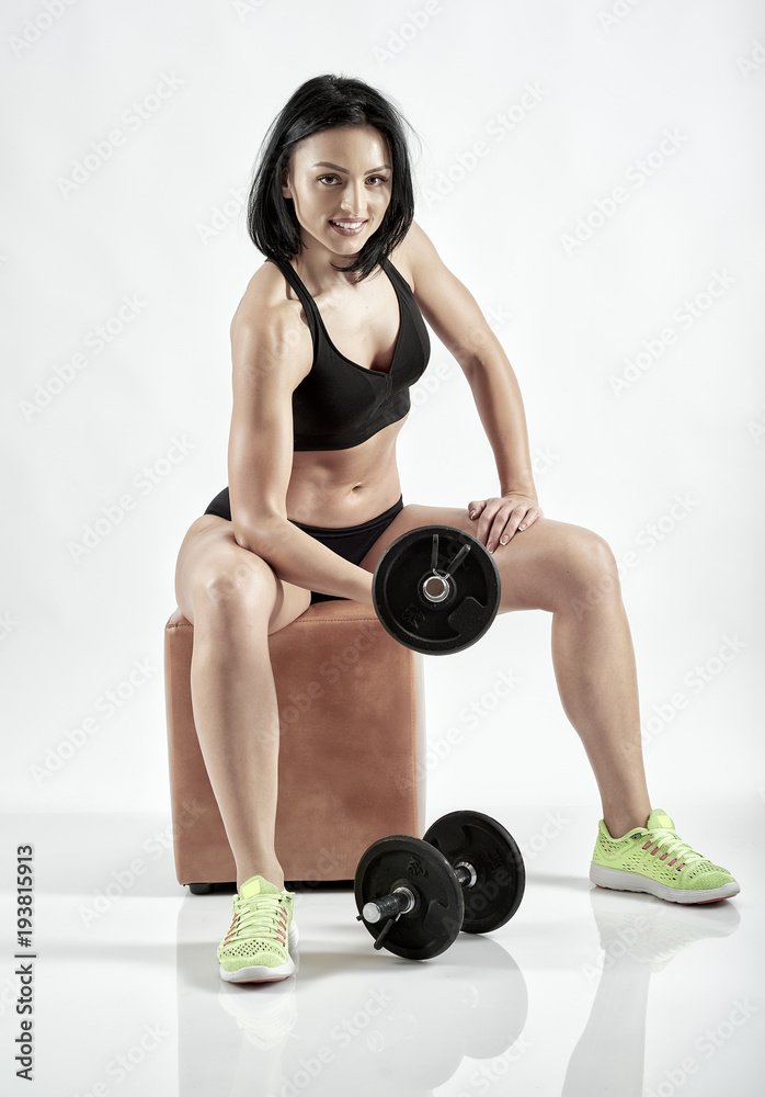 Young athletic woman working out with dumbbells Young athletic woman working out with dumbbells