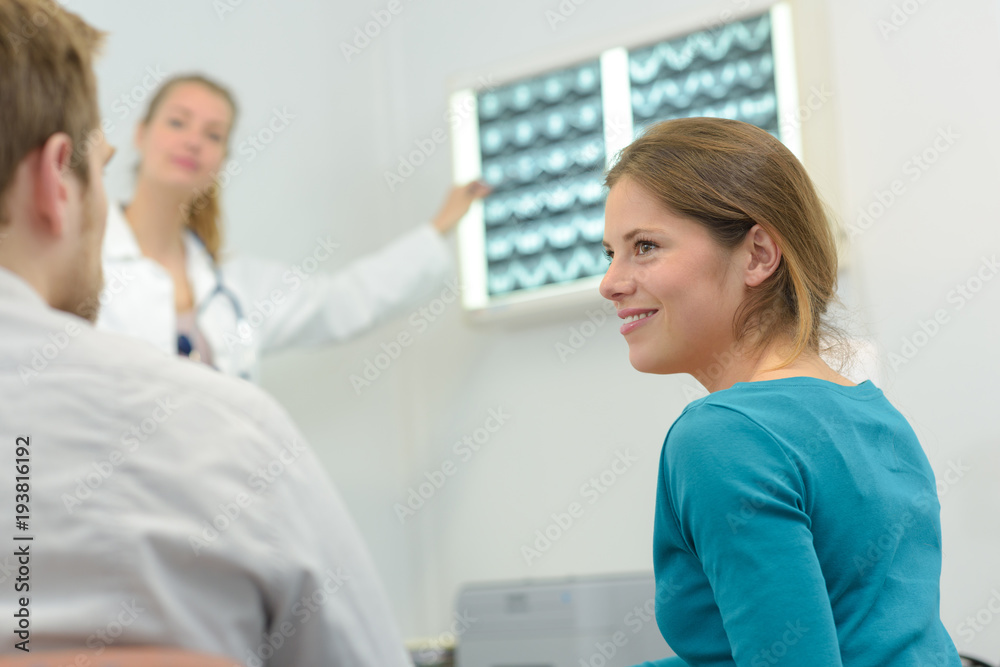 doctor showing x-ray image to female patient