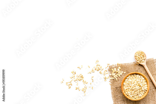 Cook oatmeal. Cereals in bowl and spoon on white background top view copy space